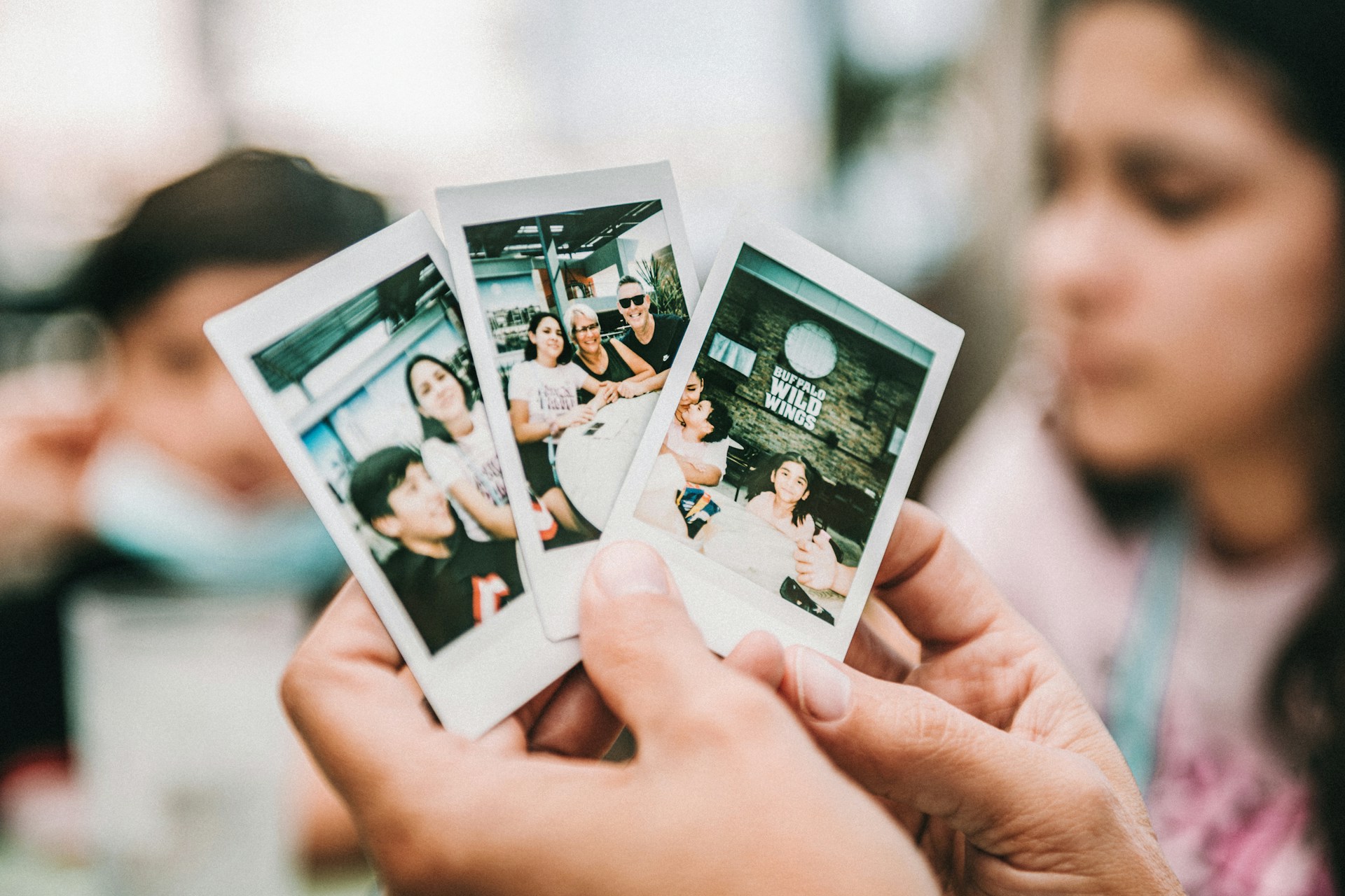 várias fotos nas mãos de uma pessoa.