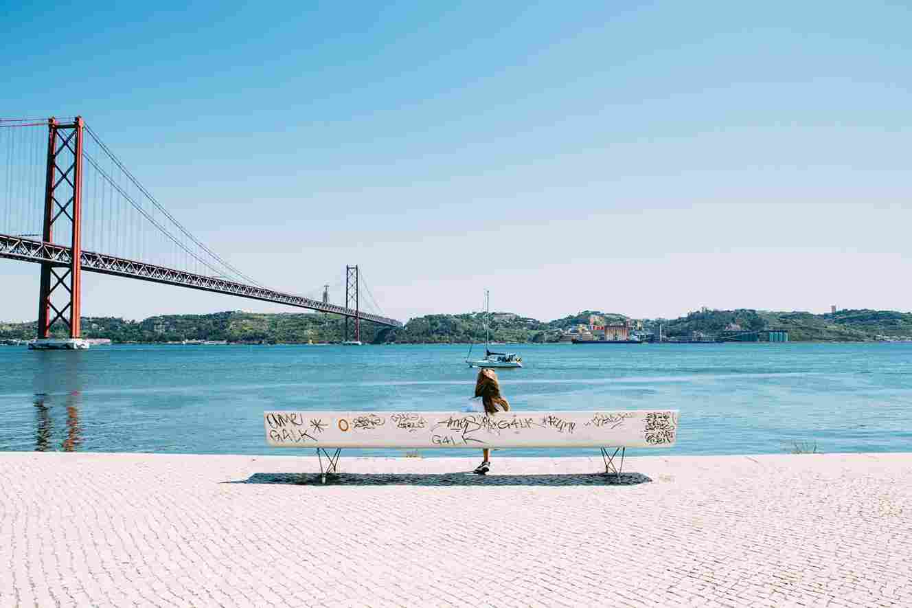 mulher admirando a vista de uma ponta em Portugal.