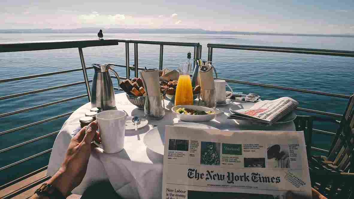 uma pessoa tomando café no deck de um cruzeiro