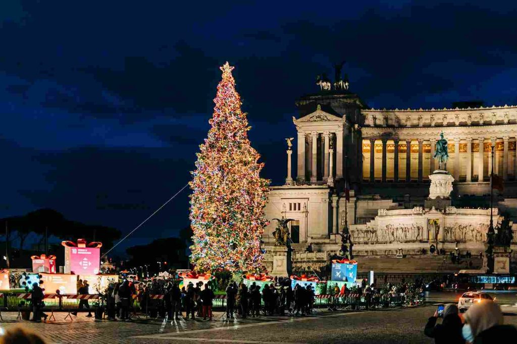 uma árvore de natal em frente á Fontana di Trevi com vários turistas