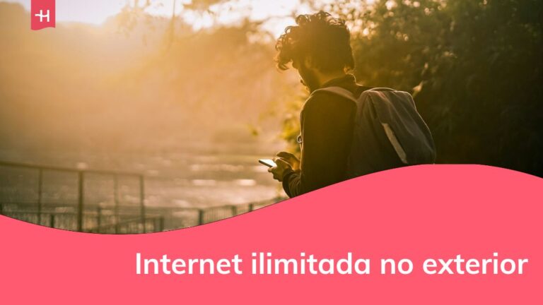 um homem mexendo no celular em meio à natureza
