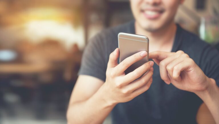 Uma figura borrada de um homem segurando um telefone.