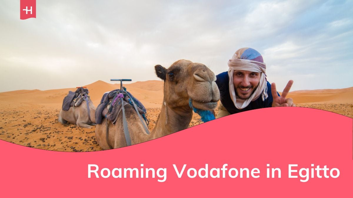 Uomo felice sorridente scatta foto selfie con un cammello nel mezzo del deserto