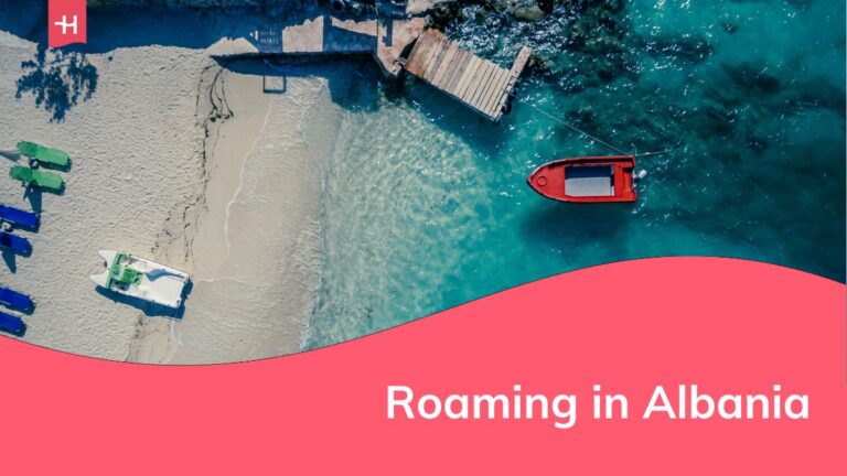 Spiaggia albanese con una barca rossa sull'acqua e il sottotitolo che dice "Roaming in Albania" su sfondo rosso.