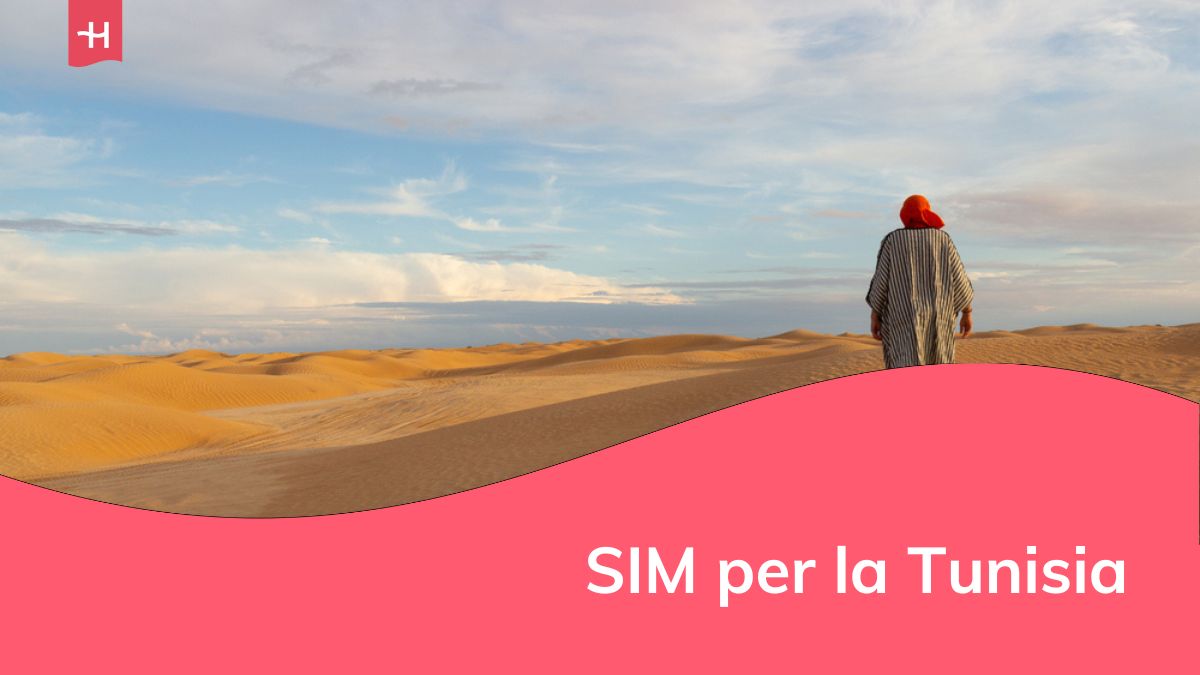 Un turista maschio in abiti berberi cammina sulle dune di sabbia nel deserto del Sahara, in Tunisia.