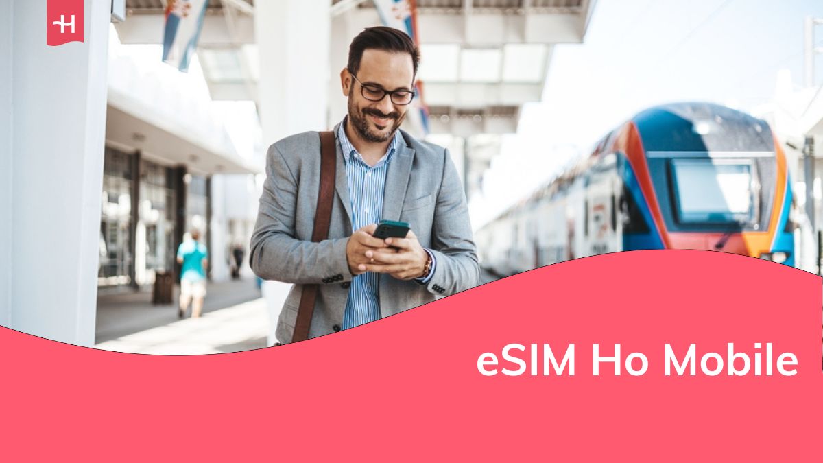 Uomo d'affari sicuro di sé che parla al cellulare mentre cammina fuori dalla stazione ferroviaria con una valigia.
