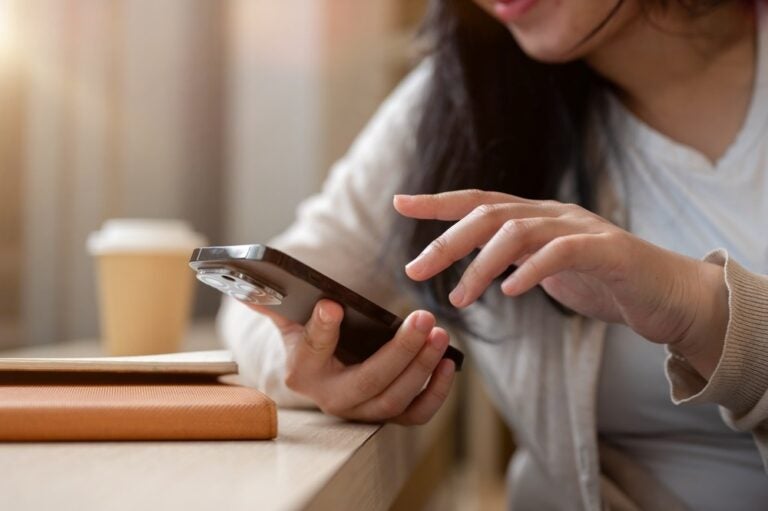 Una donna che usa il suo smartphone, messaggiando con qualcuno o navigando sul telefono.