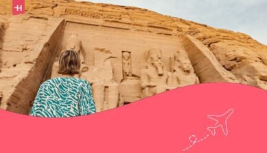 Una donna vista di spalle mentre osserva il Grande Tempio di Ramses II ad Abu Simbel, nell'Alto Egitto