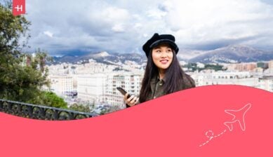 Ragazza asiatica felice mentre usa il telefono e viaggia a Genova, Italia