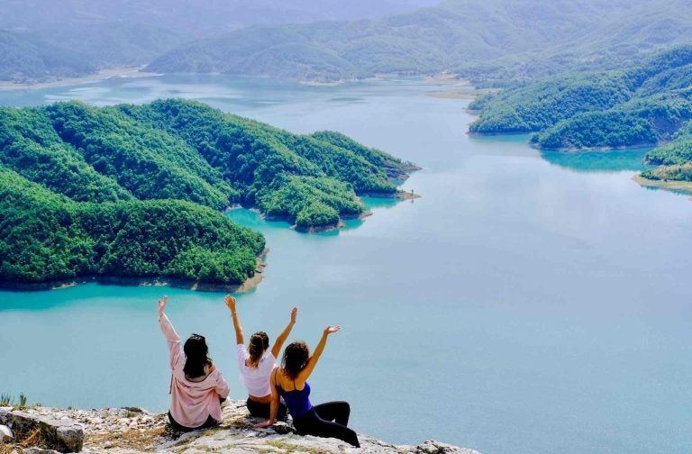 Tre donne sedute di fronte ad una vista panoramica in Albania.