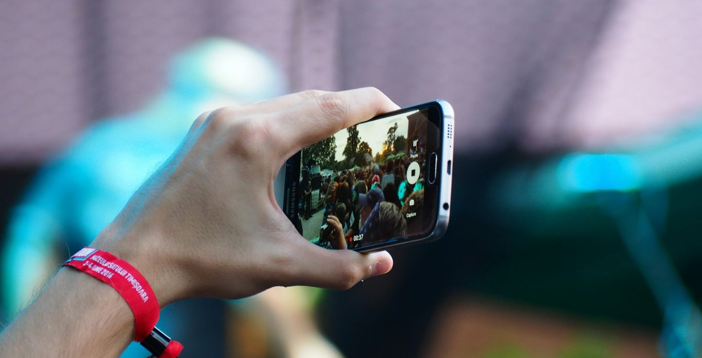 Una persona che registra un concerto con il suo cellulare.