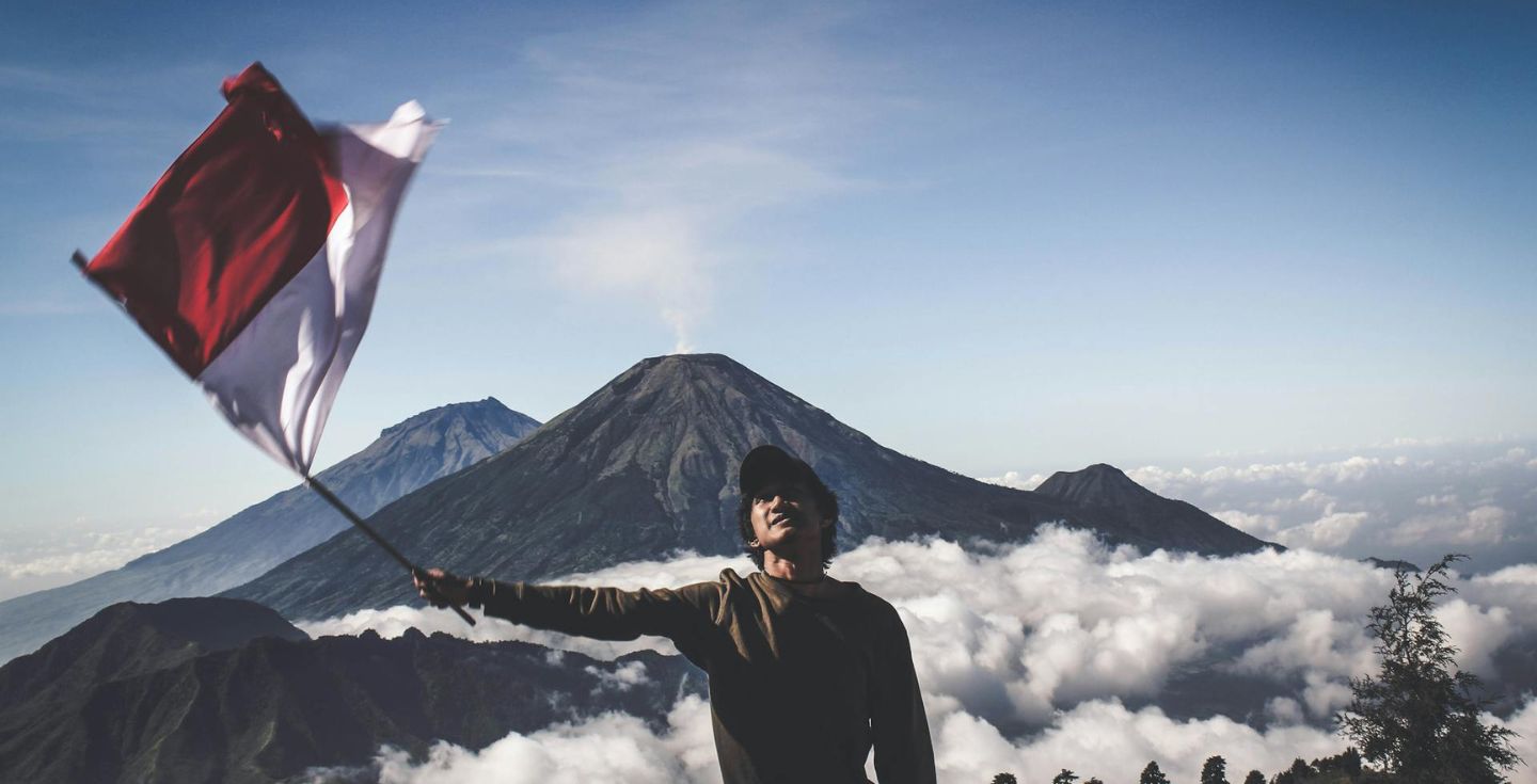 Uomo con la bandiera indonesiana in mano a Sukorejo, Jawa Tengah, Indonesia