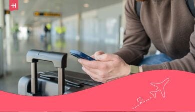 Ritratto di un uomo sorridente che si rilassa all'aeroporto con una borsa e un cellulare
