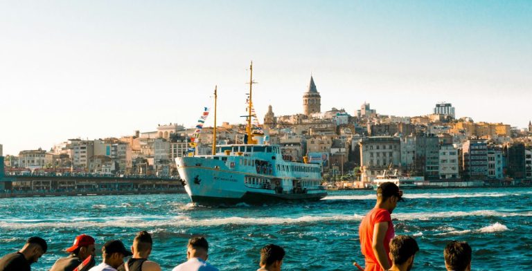 Gruppo di turisti osserva una barca a Eminönü İskele, Turchia