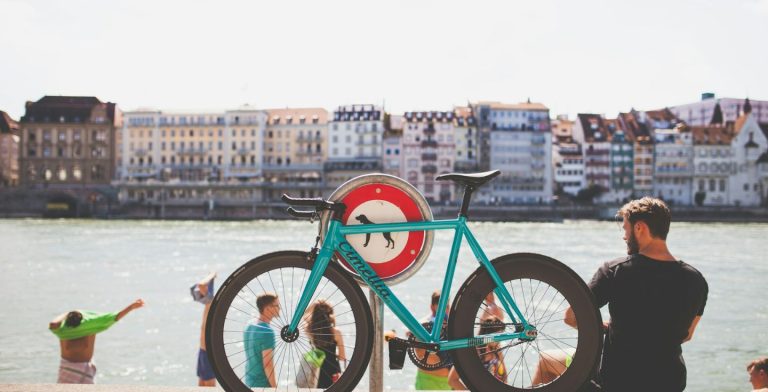 Uomo con bicicletta e gruppo di turisti a Basilea, Svizzera