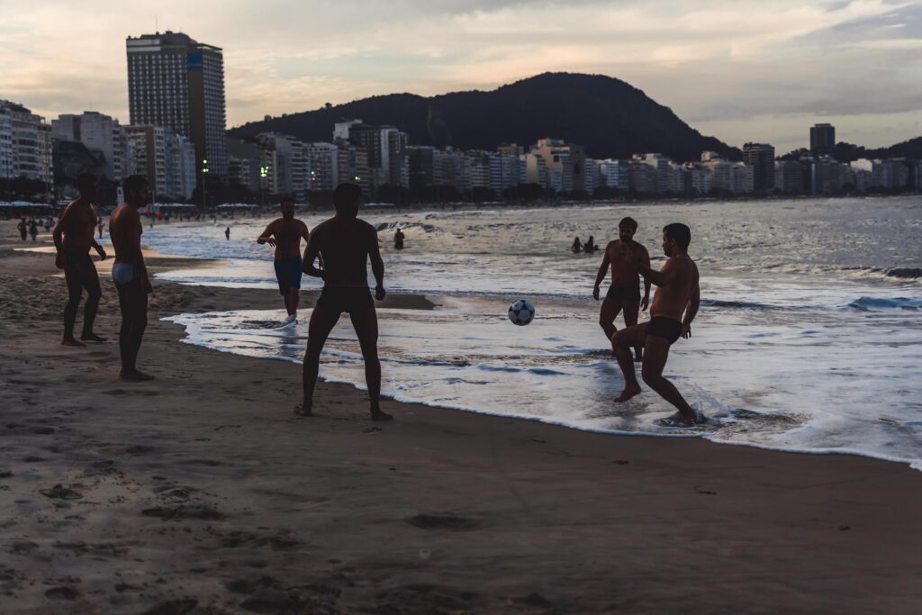 Uomini che giocano a palla in riva al mare, Rio de Janerio, Brasile