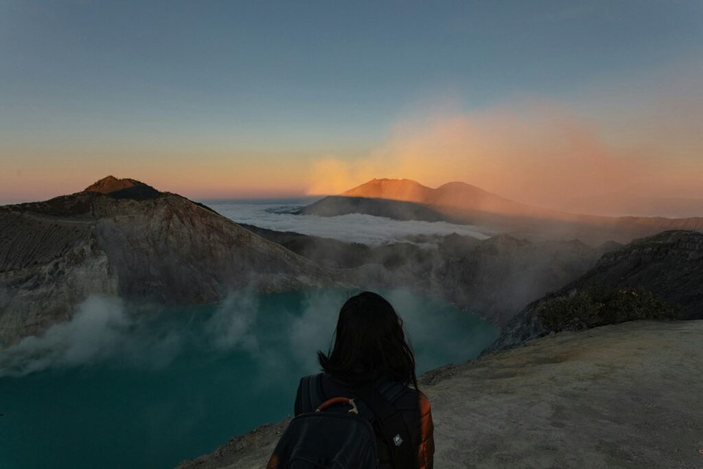 Donna su una montagna che guarda l'alba a Giava