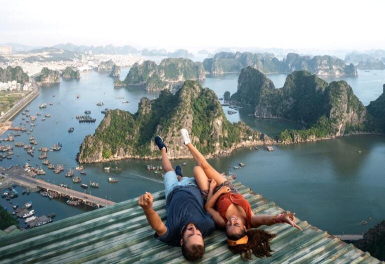 Una coppia di backpacker si gode il viaggio nel sud-est asiatico con una splendida vista sulla baia di Halong, in Vietnam