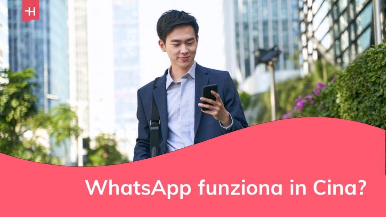 Giovane uomo d'affari asiatico che guarda i messaggi sul cellulare mentre cammina per le strade del centro di una città moderna.