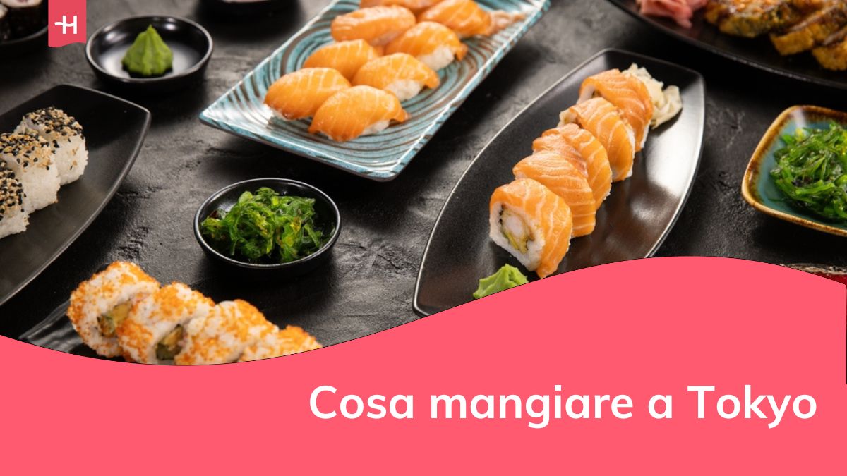 Vista dall'alto della cucina tradizionale giapponese. Set di rotoli di sushi con salmone, tonno e verdure serviti su un tavolo di pietra nera.