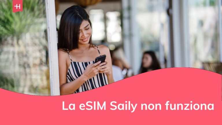 Donna del Sud-Est asiatico sorridente mentre usa e controlla il suo smartphone in una soleggiata giornata estiva.