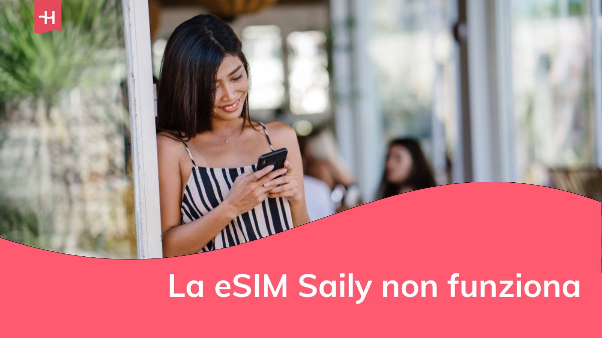 Donna del Sud-Est asiatico sorridente mentre usa e controlla il suo smartphone in una soleggiata giornata estiva.