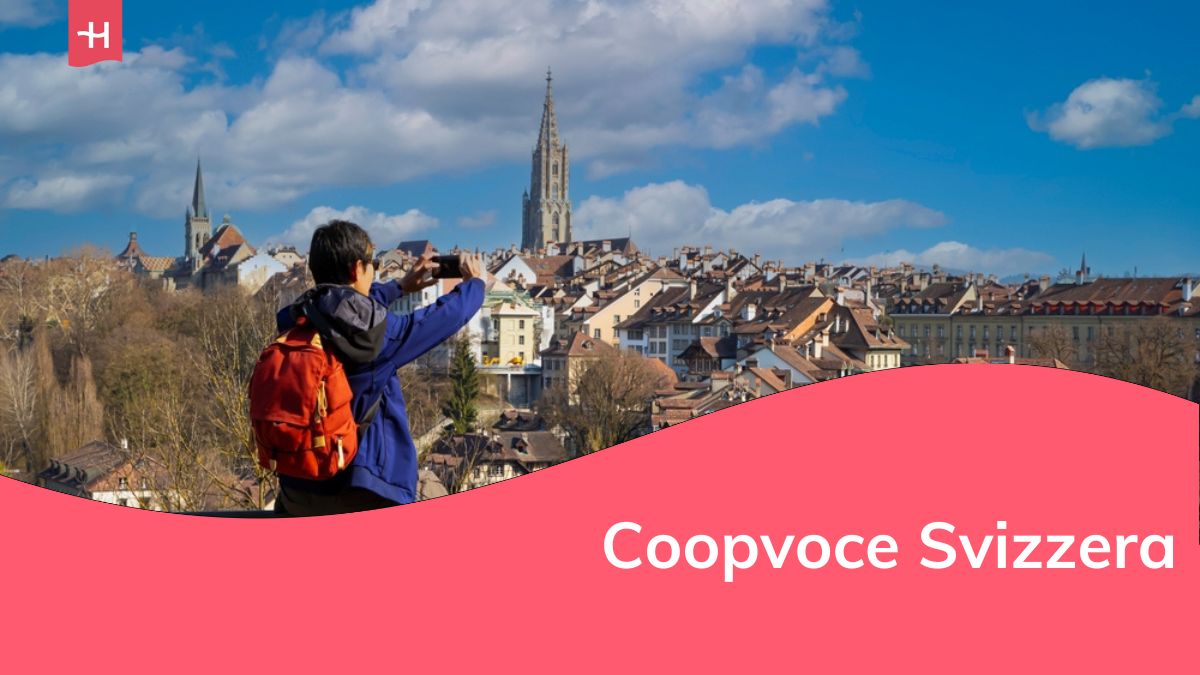 Vista posteriore di un giovane turista con zaino che scatta una foto con lo smartphone nella città vecchia di Berna, capitale della Svizzera.