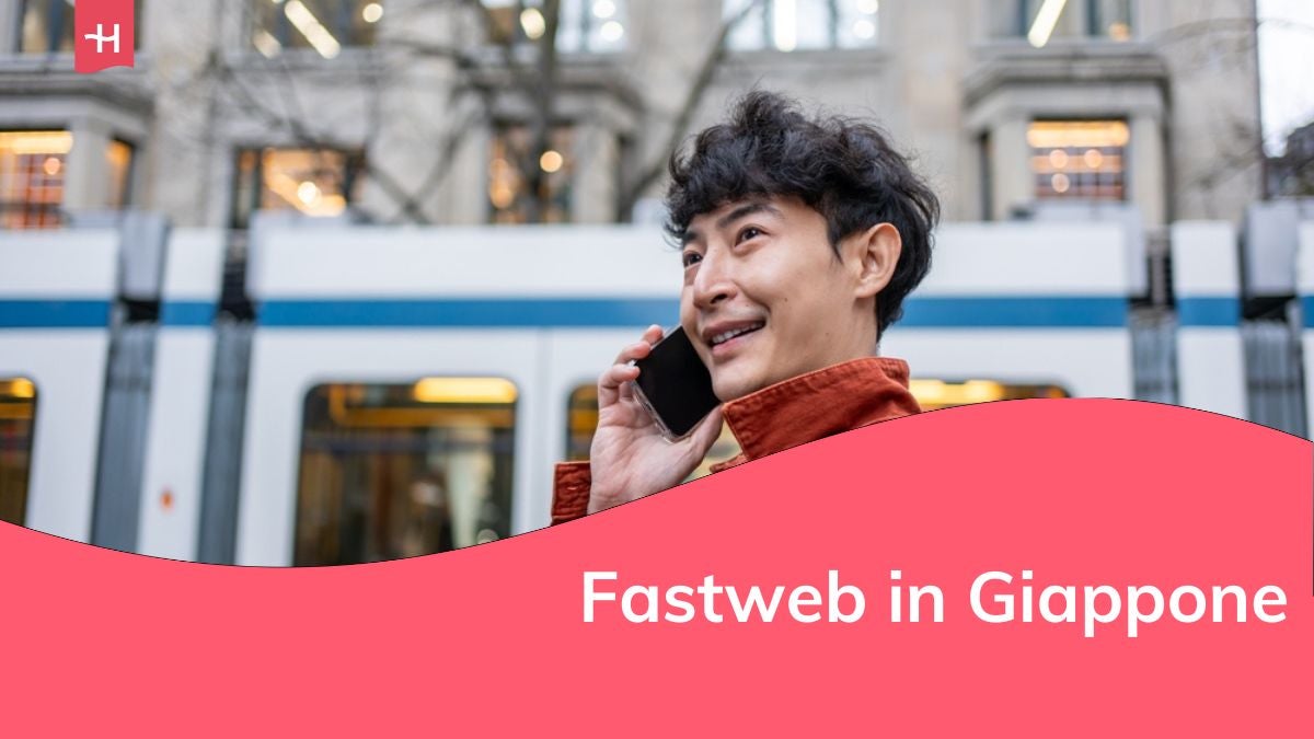 Un giovane asiatico che parla al telefono mentre cammina in città.