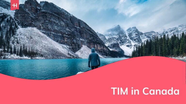 Viaggiatore solitario che cammina sul molo circondato dalle Montagne Rocciose sul lago Moraine nel Parco Nazionale di Banff, Alberta, Canada