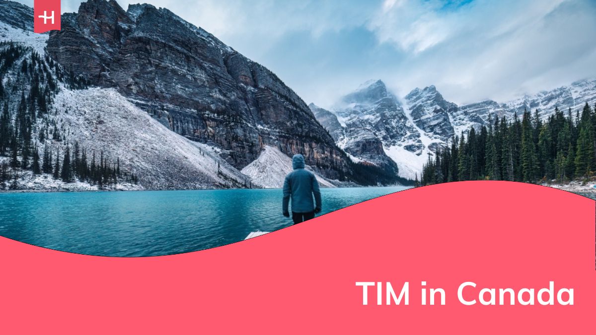 Viaggiatore solitario che cammina sul molo circondato dalle Montagne Rocciose sul lago Moraine nel Parco Nazionale di Banff, Alberta, Canada
