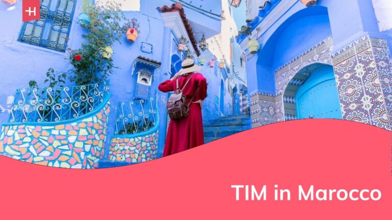 Giovane turista in abito rosso che passeggia nella medina della città blu di Chefchaouen.