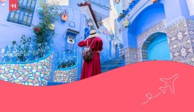 Giovane turista in abito rosso che passeggia nella medina della città blu di Chefchaouen.