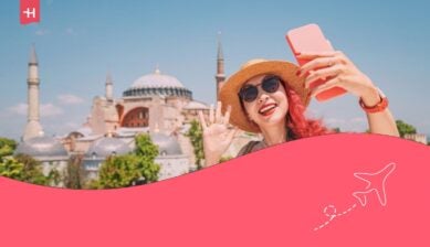Una donna turca fa un selfie di fronte a Santa Sofia, scattando il punto di riferimento storico durante le sue vacanze estive a Istanbul