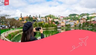 Giovane donna che scatta una foto al lago Sapa con riflessi e cielo blu nella provincia di Lao Cai, Vietnam