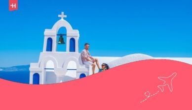Una coppia di uomo e donna che guardano il tramonto durante una vacanza a Santorini, in Grecia.