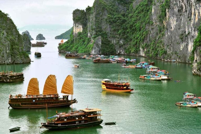 Junks turistici e villaggio galleggiante a Halong Bay, Vietnam.