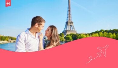 Una giovane coppia di innamorati durante un appuntamento romantico vicino alla Torre Eiffel, su un ponte sulla Senna a Parigi, in Francia