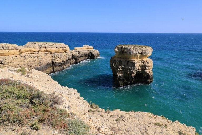 Uno scoglio in mare nella baia della spiaggia di Ponta Pequena, in Algarve, Portogallo.