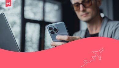 Giovane che usa il portatile e il cellulare in ufficio