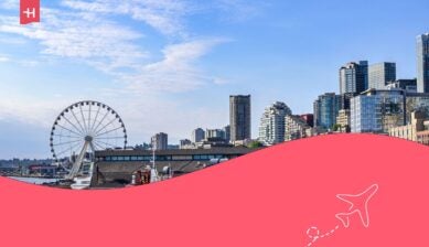 I moli sul lungomare e la baia di Elliott con una motovedetta dei vigili del fuoco e lo skyline di Seattle sotto un bel cielo