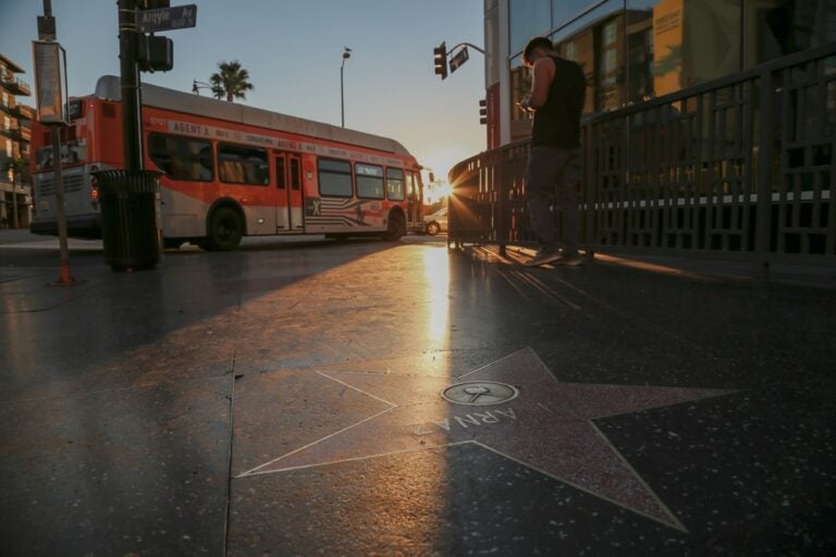 L'alba sulla Walk of Fame di Hollywood Boulevard mentre passa un autobus urbano.