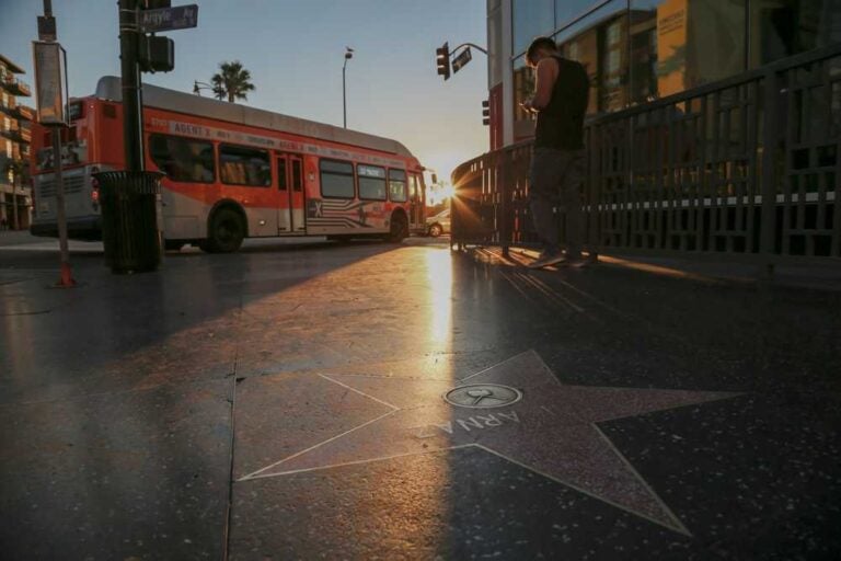 L'alba sulla Walk of Fame di Hollywood Boulevard mentre passa un autobus urbano.