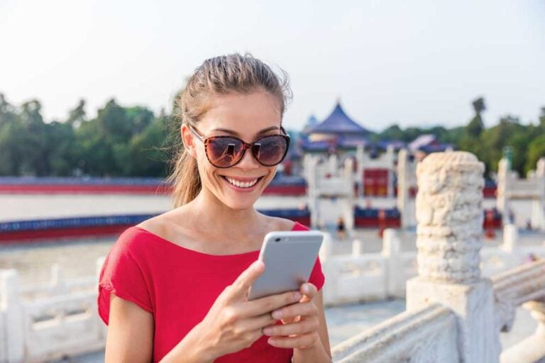 Turista che utilizza un'app sul telefono per trovare indicazioni stradali e una guida durante il viaggio.