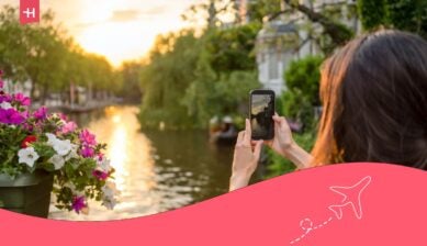 Una giovane turista ad Amsterdam scatta delle foto mentre ammira un bellissimo tramonto su un ponte