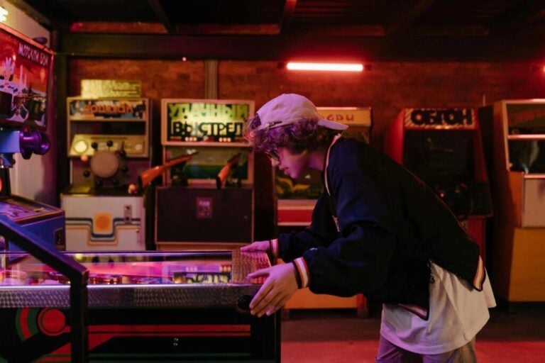 Persona che gioca in un arcade.