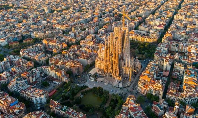 Vista aerea del quartiere residenziale dell'Eixample di Barcellona e della Basilica della Sagrada Familia all'alba.