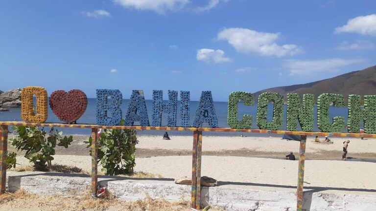 Cartello con la scritta “Io amo Bahia Concha” di fronte al mare