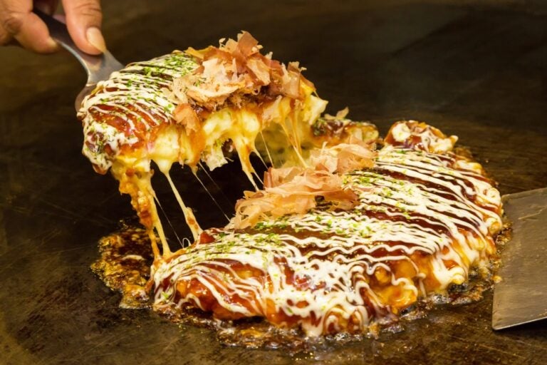 Okonomiyaki su una piastra di ferro.