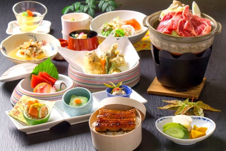 Cena giapponese di lusso a base di kaiseki servita in stoviglie tradizionali.