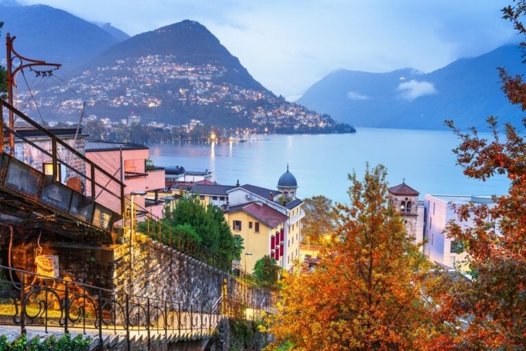Lugano, Svizzera paesaggio urbano con Monte Bre sul Lago di Lugano di notte.